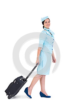 Pretty air hostess walking with suitcase