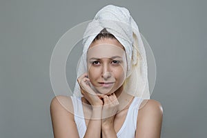 Pretty beautiful girl with perfect clean skin in a towel tenderness posing with happy smile on white background