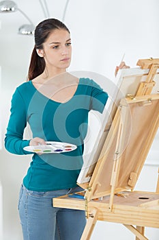 Pretty artist painting on canva