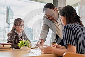 A pretty Asian female student focuses on listening to her African American teacher in the class