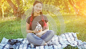 Pretty Asian Girl Hugging Bunny on Summer Nature