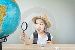 A pretty asian girl using magnifying glass