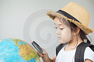 A pretty asian girl using magnifying glass