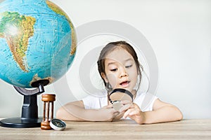 A pretty asian girl using magnifying glass