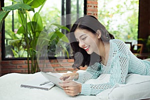 Pretty asian girl working on her school project at home