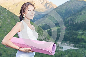 Pretty asian girl with yoga mat going to fitness exercises