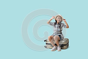 Pretty asian little girl sits on a suitcase adventure vacation travel trip dream concept