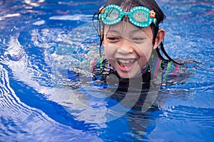 Pretty asian little girl in swimming pool