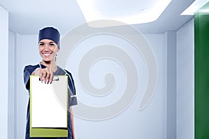 Pretty asian nurse with stethoscope showing blank clipboard for