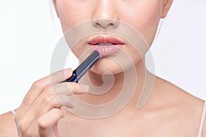 Pretty asian woman applying lipstick, isolated on white