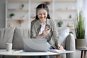 Pretty asian woman attending video conference with co-workers