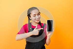 Pretty asian woman holding smartphone and pointing finger to the smartphone