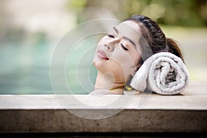 Pretty asian woman lying on the poolside