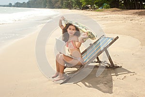 Pretty Asian woman relax working with laptop on beach bed .