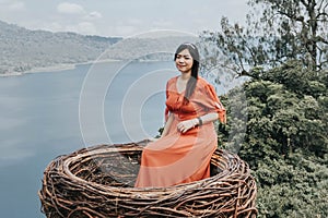 Pretty Asian woman is sitting on straw nest