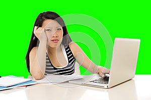 Pretty asian woman student overworked on her laptop on green screen croma key