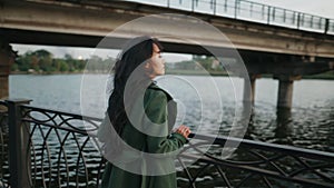 Pretty asian woman walking on river embankment enjoying landscape