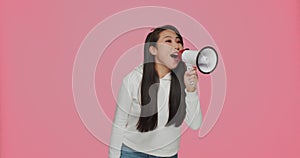 Pretty asian young girl screaming in megaphone, announce sale offer, proclaiming discount. Online store advertising