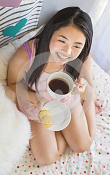 Pretty Asian Young Woman Having Breakfast in Bed