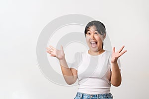 The pretty Asian young woman with surprise and shocked facial expression standing on a white background