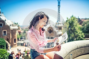 Pretty attractive girl studying map while traveling on a sunny day