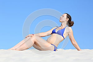 Pretty attractive woman in blue bikini sitting on