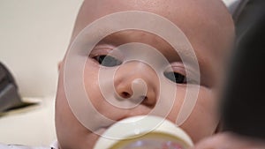 Pretty baby girl drink milk from bottle.