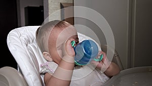 Pretty baby girl drinks water from bottle.