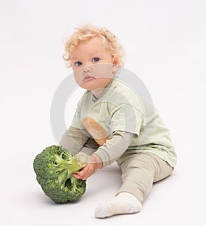 Pretty  baby girl plays with broccoli