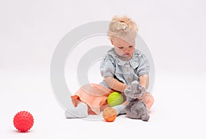 Pretty  baby girl plays with colorful balls