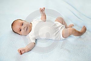 Pretty baby is lying on the carpet