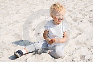 Pretty baby is playing with sand