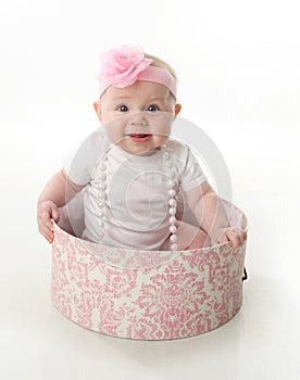 Pretty baby sitting in a hatbox