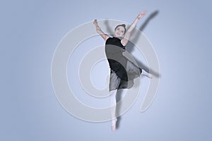 Pretty ballerina performing dances on studio