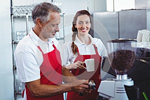 Pretty barista looking at camera and holding a mug of coffee