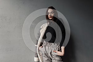 Pretty beautiful young woman in an elegant checkered jacket in a black shirt in stylish gray pants posing standing