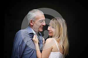 Pretty Beautiful Young Woman Hugging His Elderly Husband and Looking at Him with Passion. Age Difference Concept.