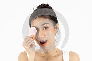 Pretty beauty young Asian woman covering her eyes with cotton pad over white  background. Healthy skin and cosmetics