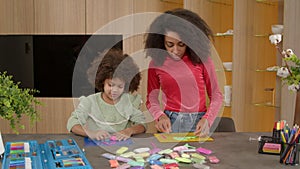 Pretty black mother and daughter creating handicraft toys from playdough