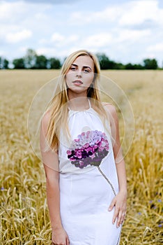 Pretty blond female in the middle of yellow wheat