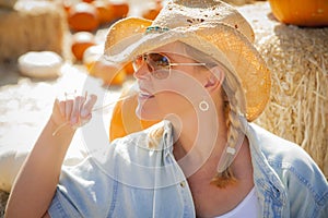 Pretty Blond Female Rancher Wearing Cowboy Hat in Pumpkin Pat