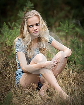 Pretty Blond Teenager Sitting In The Grass