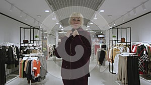 Pretty blond woman dressed in a hoodie at clothing store, static shot