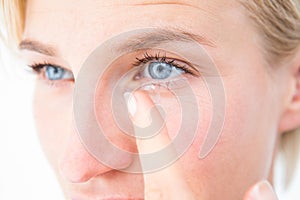 Pretty blonde applying contact lens