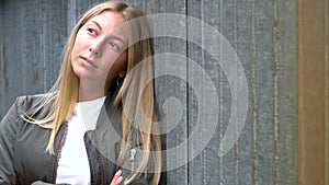 Pretty blonde girl teenager young woman looking sad or thoughtful in an urban city environment