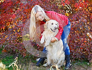 Pretty blonde girl walking with dog in the forest. Animal concept.