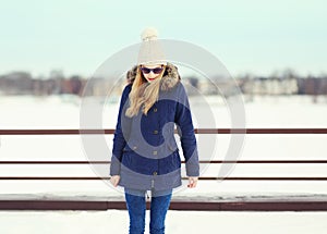 Pretty blonde girl wearing a jacket, hat and sunglasses