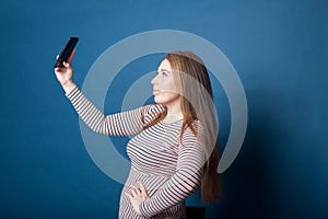 Pretty blonde plus-size girl taking a selfie with her cell phone