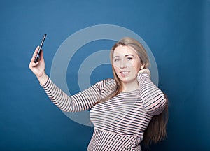 Pretty blonde plus-size girl taking a selfie with her cell phone