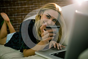 Pretty blonde relaxing on the couch using laptop